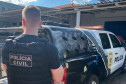 Policial civil ao lado de viatura
