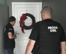 Dois policiais civiscumprindo mandado de prisão.