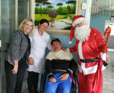 Delegada da PCPR, funcionária do lar de idosos, senhor cadeirante e papai Noel sorrindo para a foto