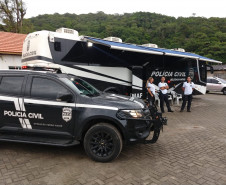 Policias civis e viaturas em frente a delegacia móvel da PCPR