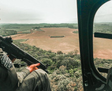 investigadora da PCPR empunha fuzil dentro de helicóptero em operação