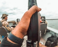 policiais dentro de barco em operação no rio paraná