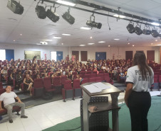 Policial civil ministrando palestra em auditório para educares da rede municipal de Matinhos