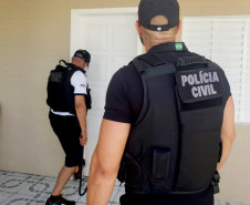 Policiais civis arrombando porta para averiguação de local