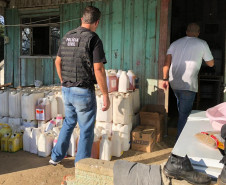 Policial civil adentrando em casa com produtos agrícolas recuperados