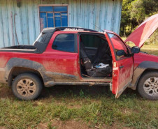 Ao lado da casa, veículo recuperado, com capô aberto