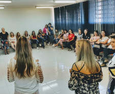 Participantes sentadas em círculo ouvindo a palestrante