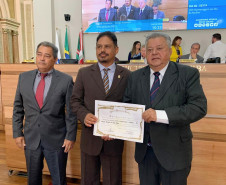 Homenageado recebendo diploma em foto posada