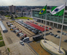 Fotografia aérea mostrando os veículos entregues, as bandeiras do Brasil e do Paraná e o Palácio Iguaçu.