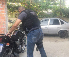 Policial civil averiguando motocicleta