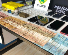 Objetos e dinheiro apreendidos, sobre a mesa