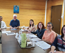 Participantes reunidos à mesa, para discutir o cronograma