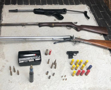 Diversas armas e munição sobre uma mesa