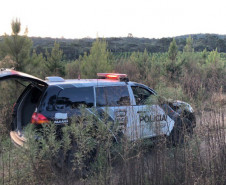 Viatura em estrada de terra, cercada por vegetação