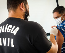 Policial civil aplicando vacina em homem