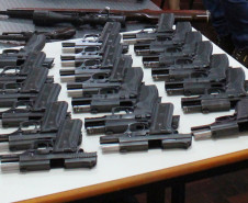 Diversas armas agrupadas sobre uma mesa