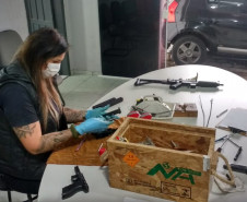 Policial civil efetuando manutenção de armas