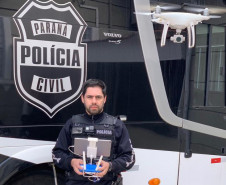 Investigador Juliano Filtrado operando um drone ao lado de ônibus da Policia Civil
