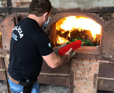 Policial civil colocando tabletes de droga no forno