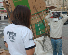 Policial civil observa transeunte colocando máscara