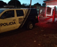 Viatura da polícia civil estacionada em frente a uma residência.