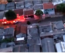 Cena aérea da mostrando casas e viaturas da polícia civil na rua