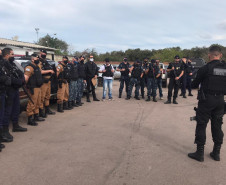 Vários policiais reunidos, recebendo instruções