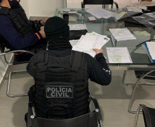 Policiais civis verificando documentos 