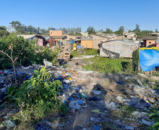 Várias casas em meio à área com muito lixo