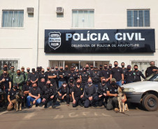 Dezenas de policiais civis posando para foto em frente à delegacia