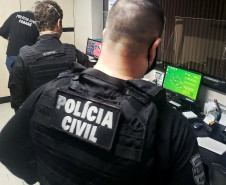 Policiais civis recolhendo material a ser recolhido