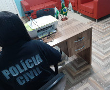 Policial de costas, no espaço exclusivo da delegacia