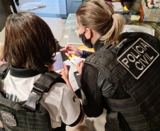Policiais civis analisando materiais