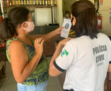 Policial civil divulgando trabalho de arrecadacao junto a comerciante