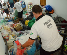 Policiais civis organizando produtos arrecadados para carregamento em caminhao