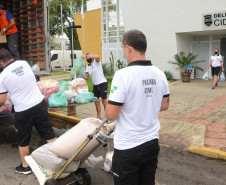 Policiais civis carregando caminhao com produtos arrecadados