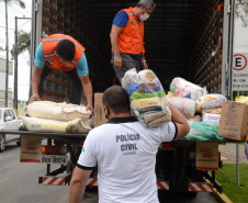 Policiais civis carregando em caminhao produtos arrecadados