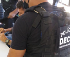 Policiais civis analisando material apreendido