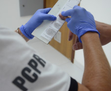 Policial civil recolhendo digitais