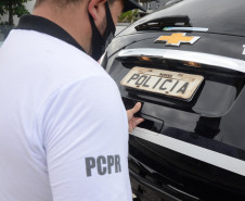 Policial civil fechando o porta malas da viatura