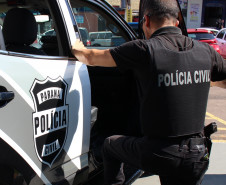 Policial civil entrando em viatura