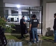 Policiais civis na calçada, em frente a local a ser investigado