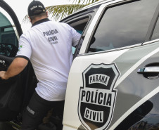 Policial civil entrando em viatura