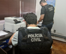 Policiais civis analisando documentos 