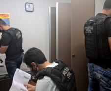 Policiais civis analisando documentos