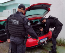 Policiais civis revistando automóvel