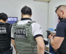 Policiais civis analisando documentos