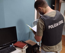 Policial civil analisando documentos