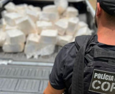 Policial civil ao lado de veiculo com drogas