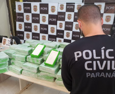 Policial civil de costas com droga apreendida